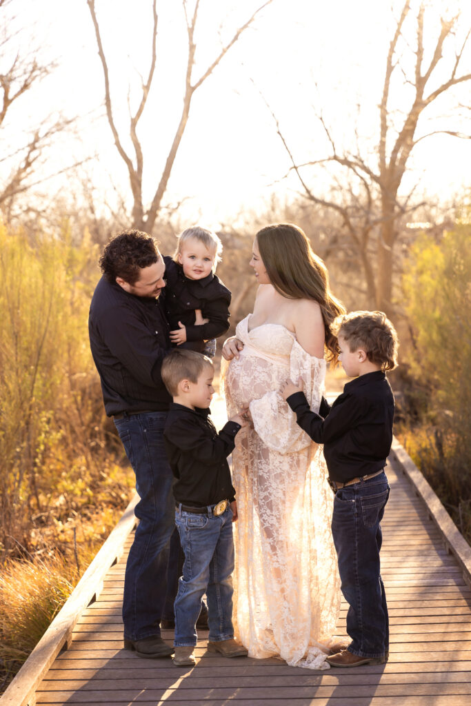 Growing family celebrating pregnancy during a maternity photography session in Midland TX